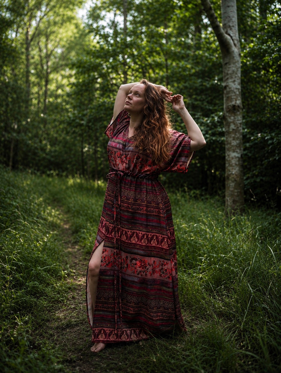 Woman in a patterned dress standing in a forest