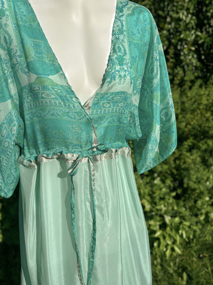 Teal patterned top and light green skirt on a mannequin against a blurred green background