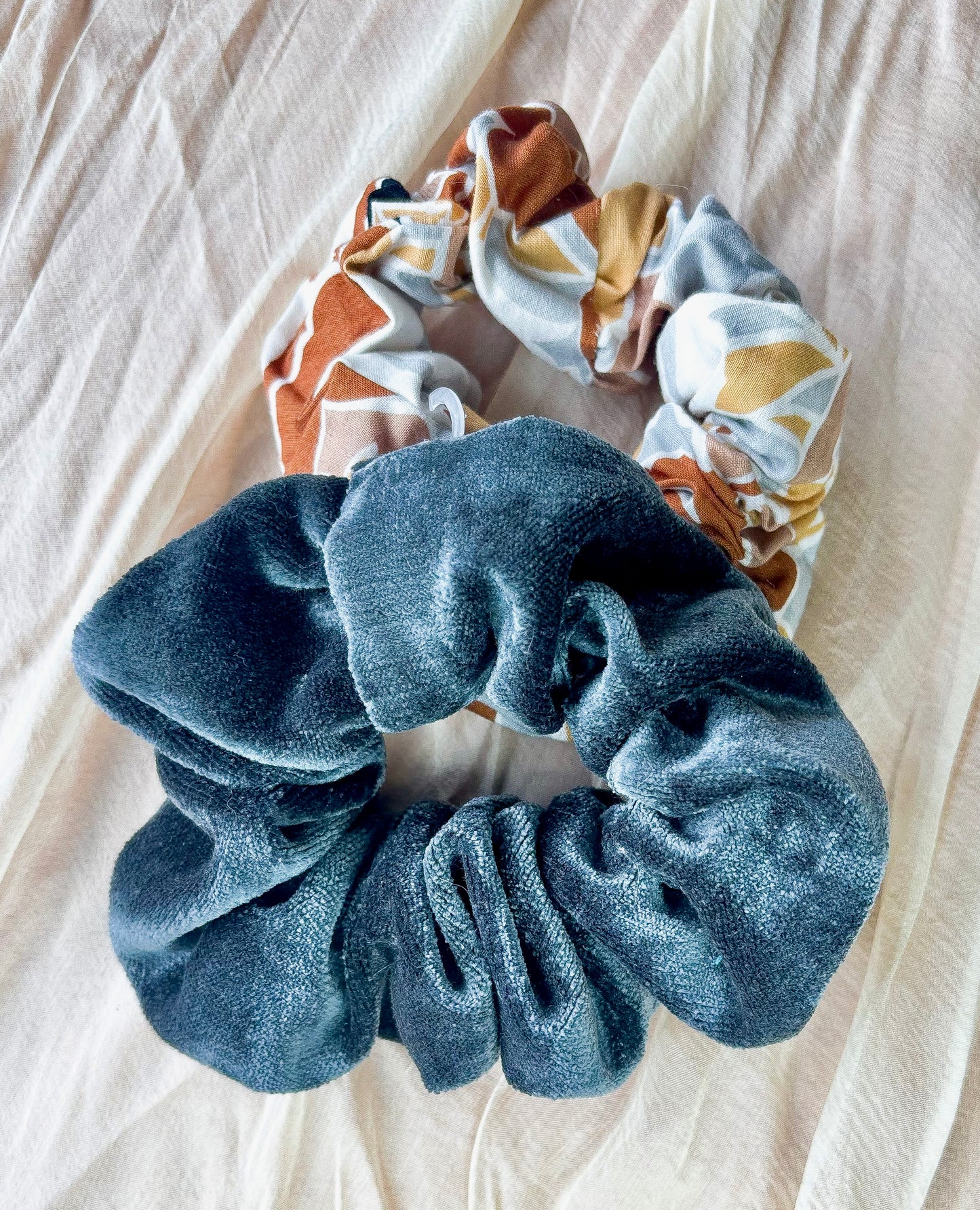 Blue scrunchie on a beige fabric background