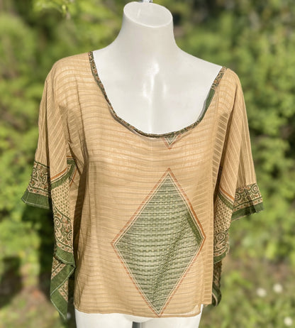 Beige and green patterned top on a mannequin with a blurred green background