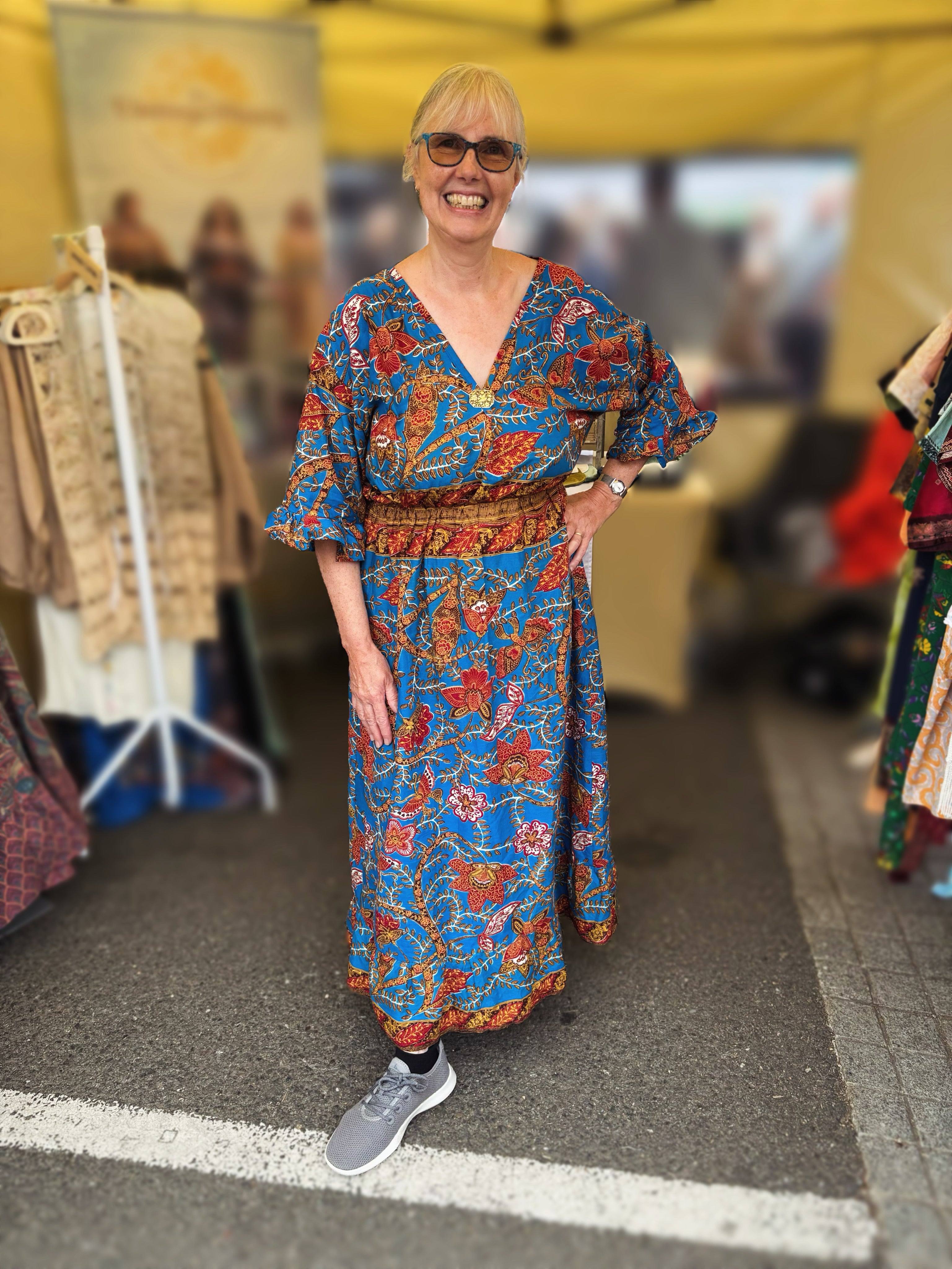 Woman in a colorful dress standing in an indoor market setting