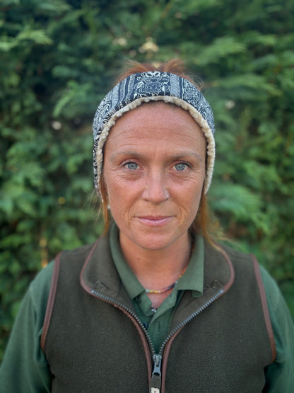 Person wearing a headband and green jacket against a blurred green background