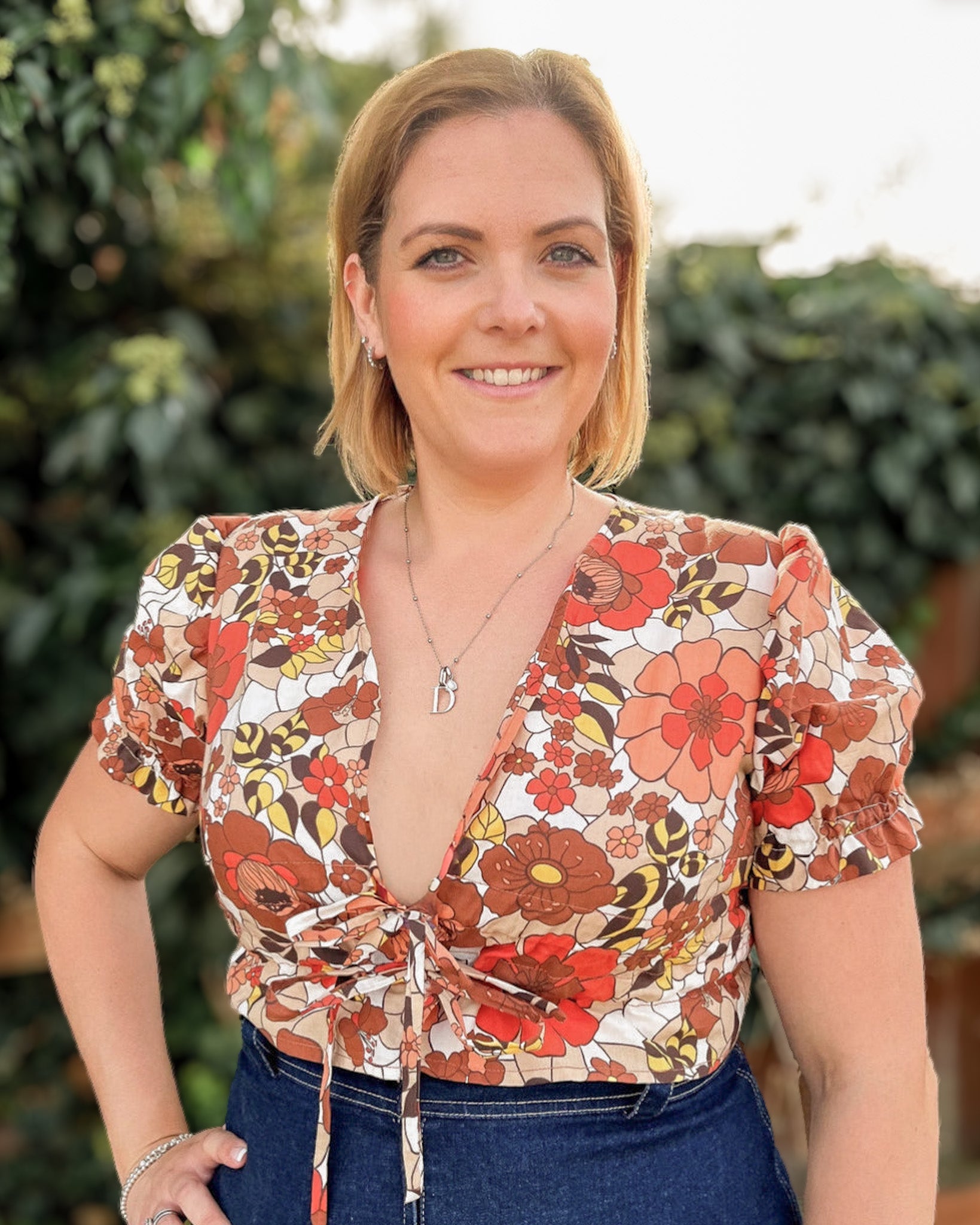 Woman wearing a floral blouse with a blurred green background