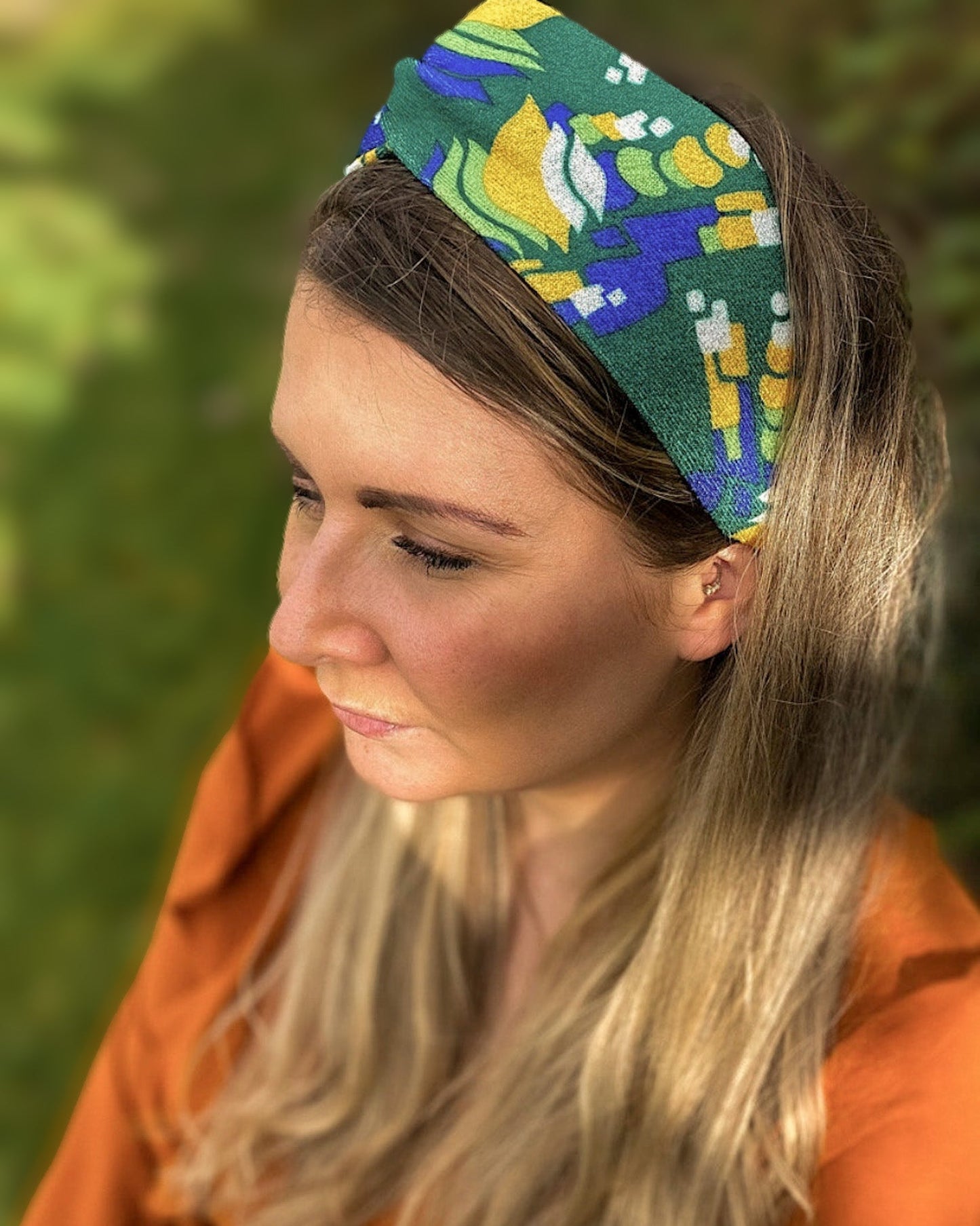 Woman wearing a colorful headband with a blurred green background