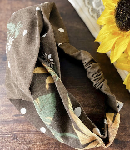 Floral patterned headband on a wooden surface with a sunflower in the background