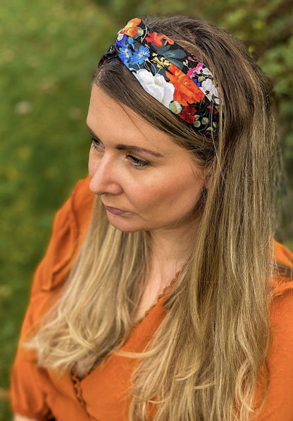 Woman wearing a colorful floral headband with a blurred green background