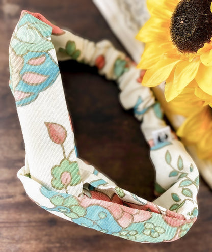 Floral-patterned headband on a wooden surface with a sunflower in the background