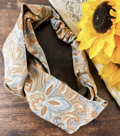 Patterned headband with scrunchies and sunflowers on a wooden surface