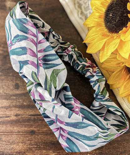 Floral-patterned headband on a wooden surface with sunflowers.