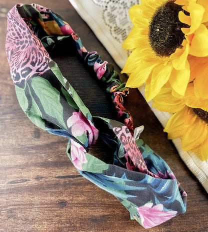 Floral patterned headband on a wooden surface with sunflowers in the background